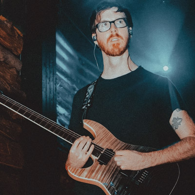 Guitar player stands on stage with guitar